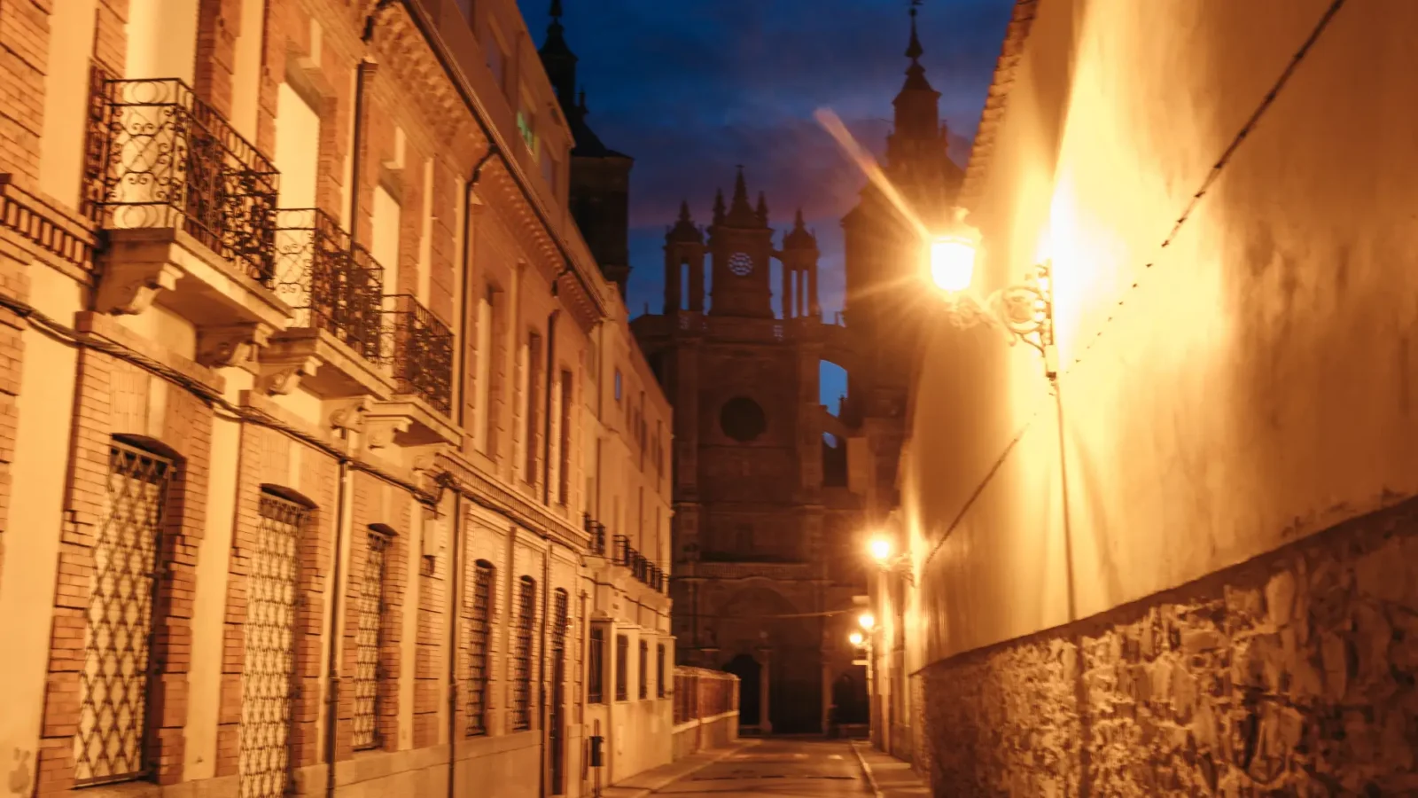 A lamplit old-town street at dusk in Astorga, León, Spain