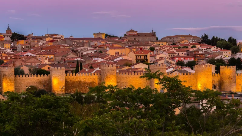 Ávila's complete medieval walls seen across the plain at dusk, Castilla y León, Spain