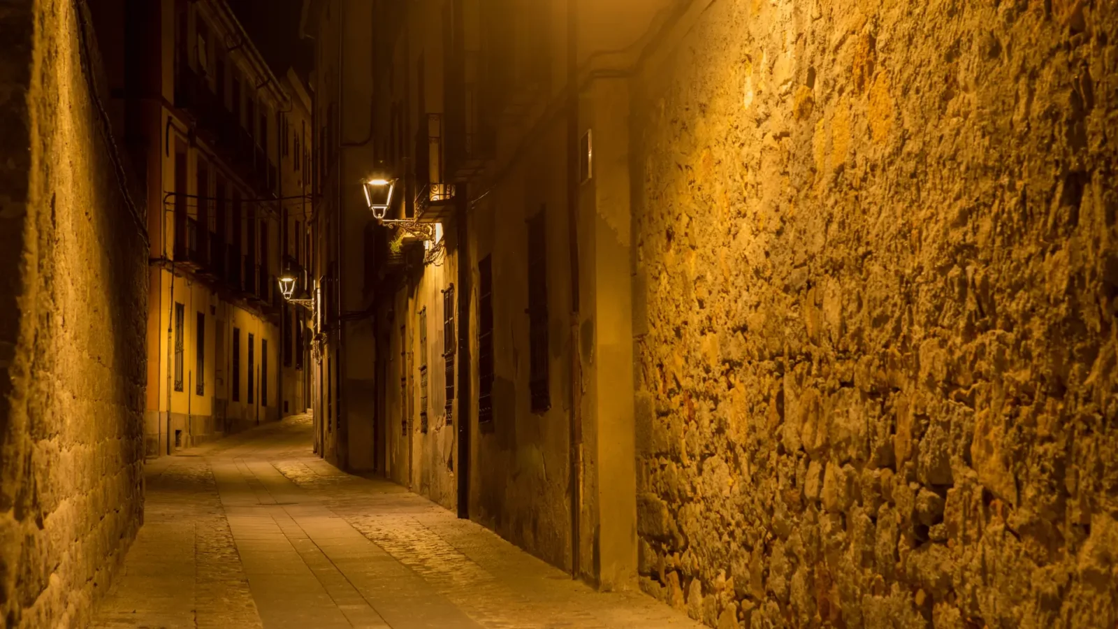 A lamplit stone lane in Ávila's old town at night, Castilla y León, Spain