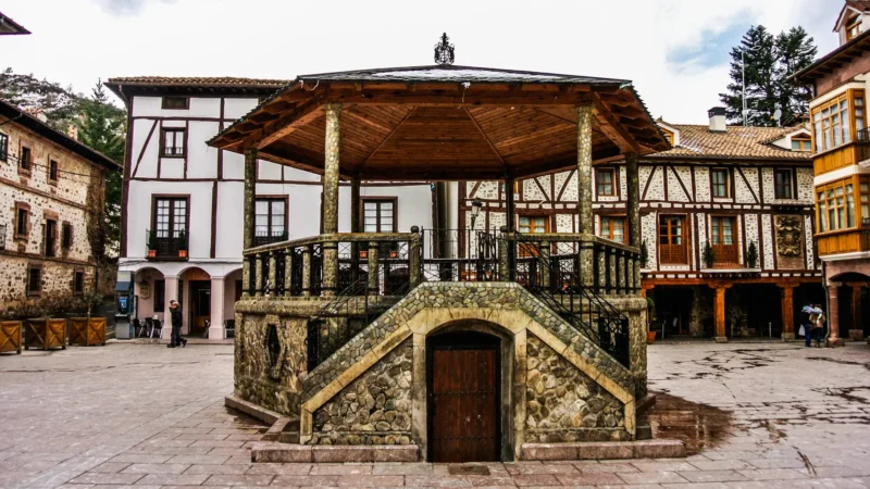 The stone kiosk on Plaza del Quiosco in Ezcaray, with the mountains behind, La Rioja, Spain