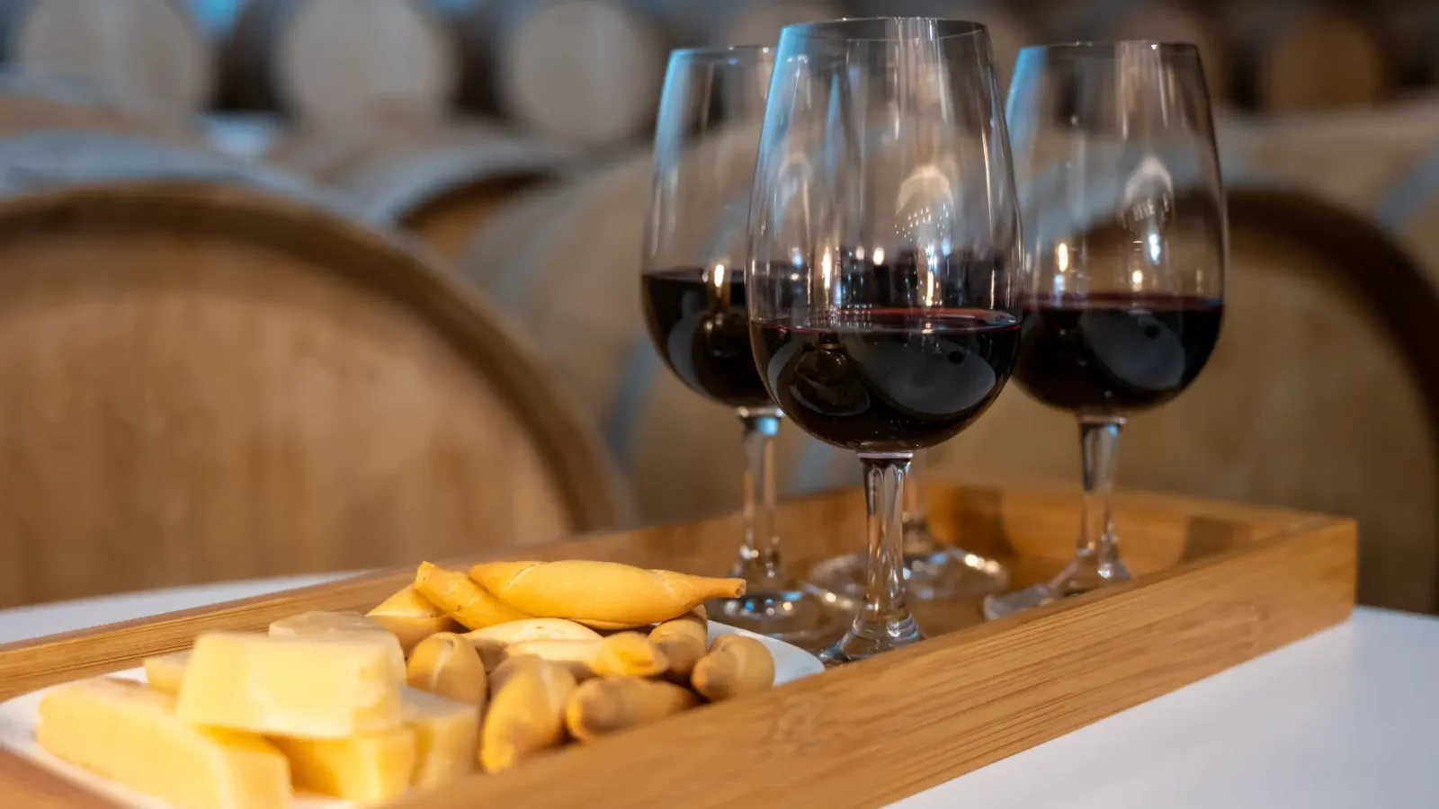 Glasses of red Rioja on a tasting board in front of cellar barrels in Haro, La Rioja, Spain