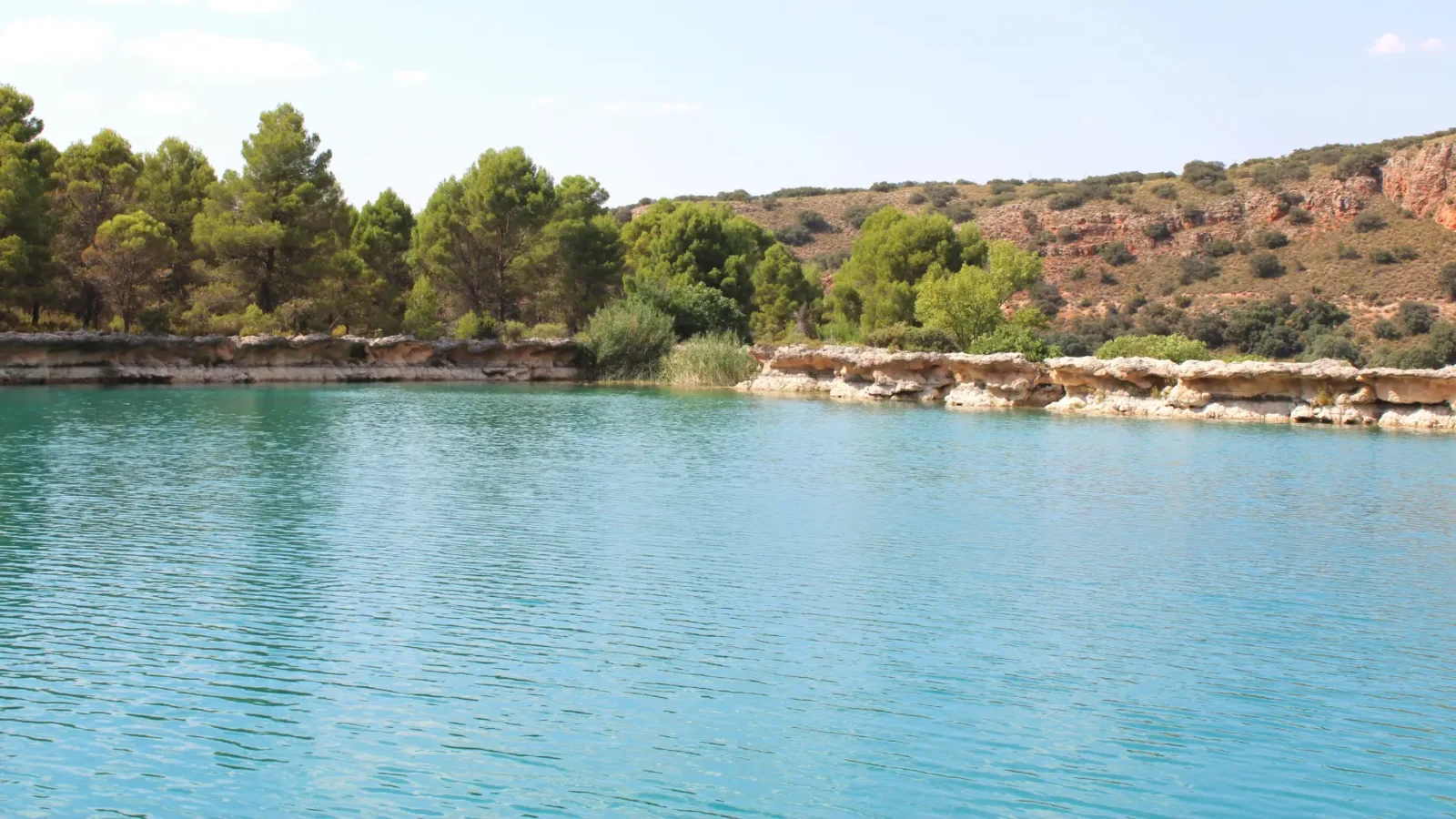 A quiet pine-fringed lagoon at the Lagunas de Ruidera, Castilla-La Mancha, Spain