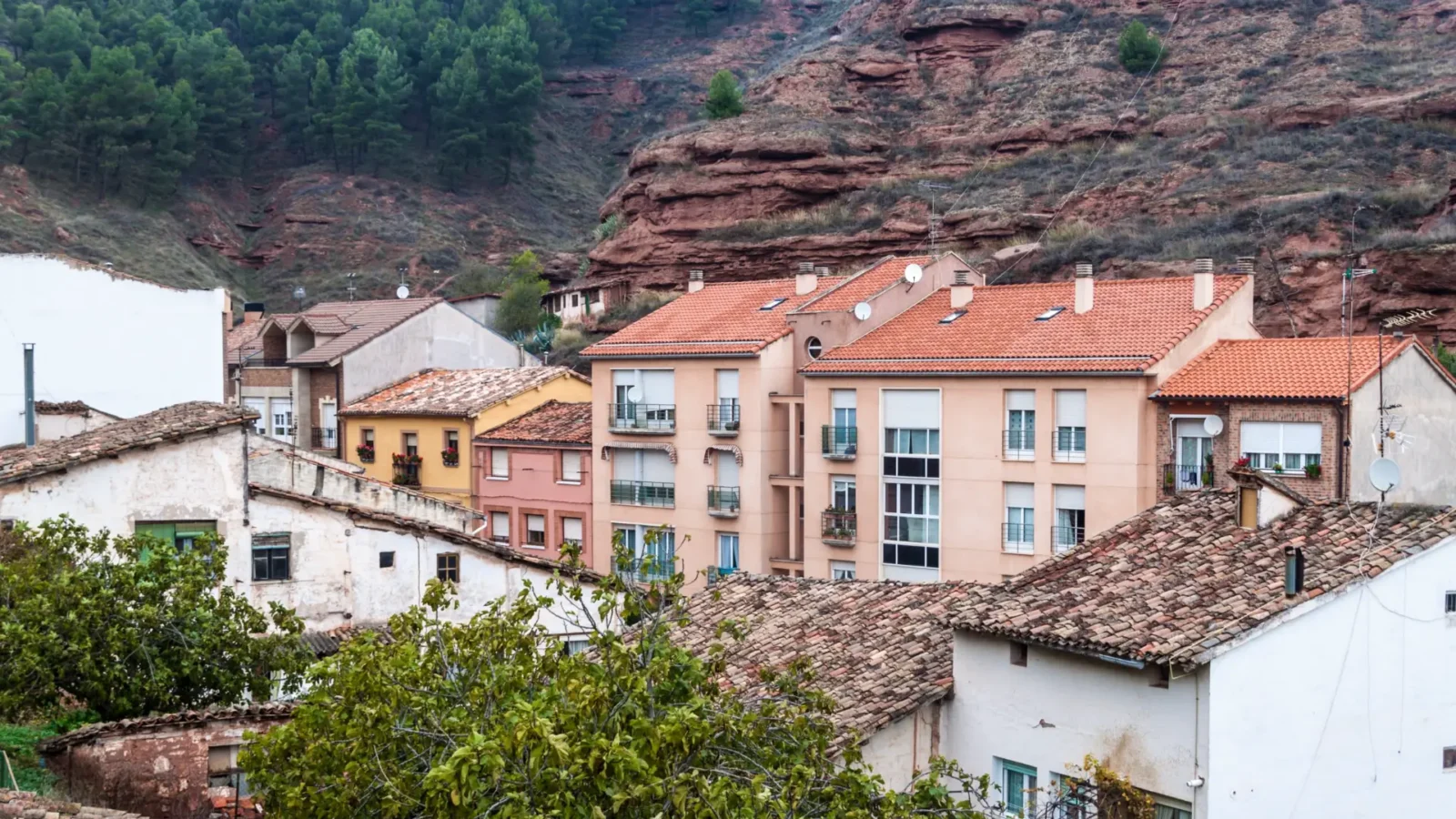 Terracotta rooftops of Nájera old town backed by the red cliffs, La Rioja, Spain