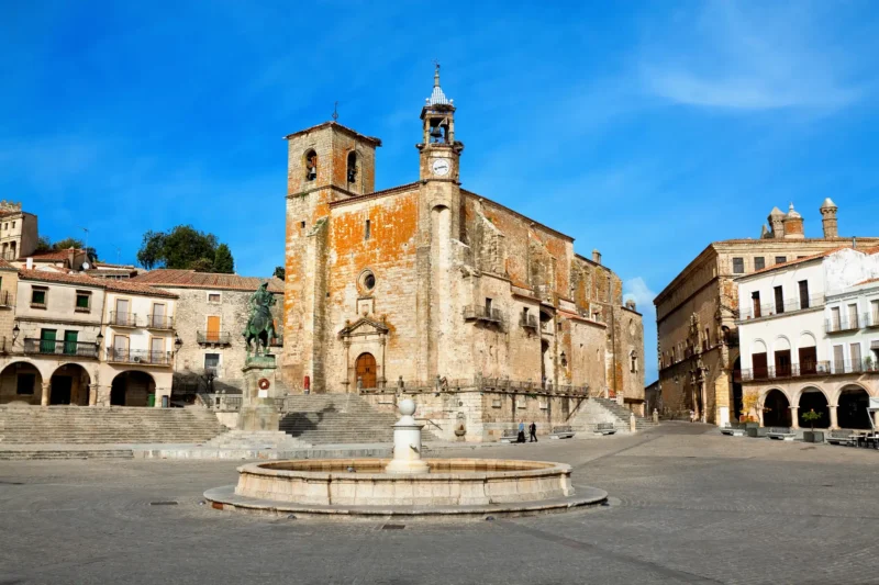 The grand Plaza Mayor of Trujillo with the Pizarro equestrian statue and the church of San Martín.