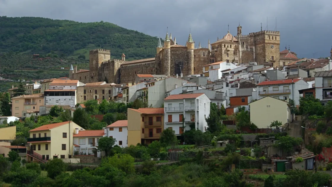 The Royal Monastery of Guadalupe rising above the village and hills, Extremadura, Spain
