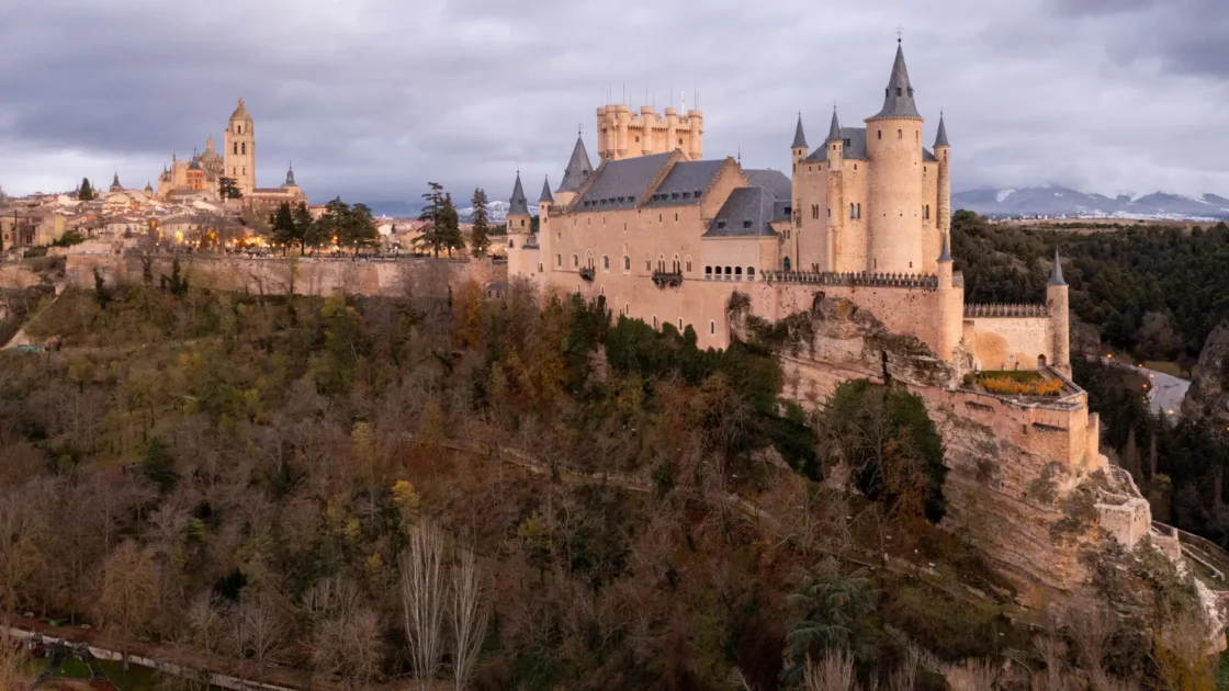 The Alcázar of Segovia on its clifftop above wooded slopes, Castilla y León, Spain