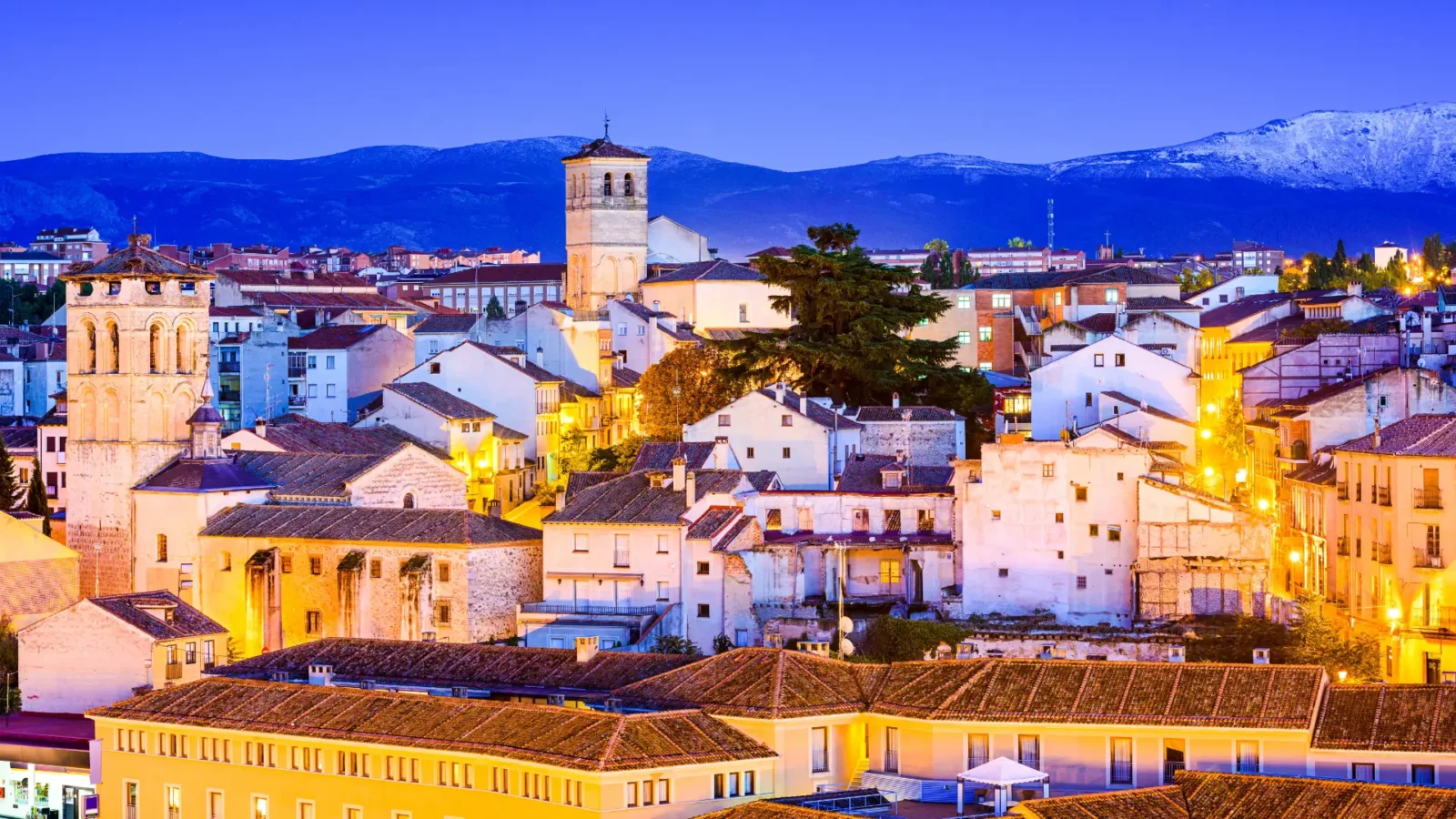 A cobbled street in the old town of Segovia at dusk, with the sierra beyond, Castilla y León, Spain