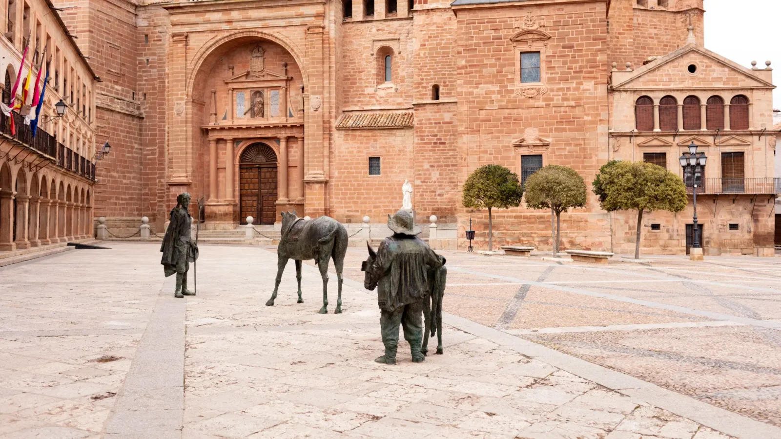 The façade of San Andrés and the Don Quixote sculptures on the Plaza Mayor, Villanueva de los Infantes, Spain