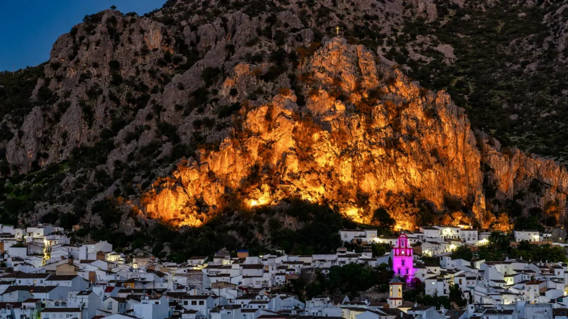 The white town of Ubrique lit below its limestone cliffs at dusk, Andalucía, Spain