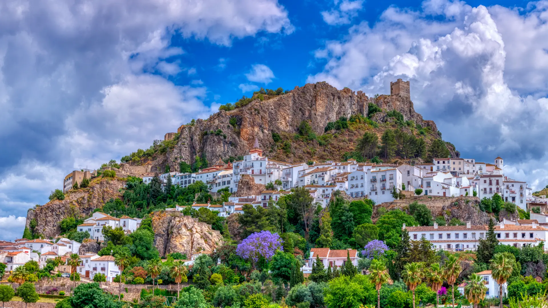 The white village and castle tower of Zahara de la Sierra under a dramatic sky, Cádiz, Andalucía, Spain