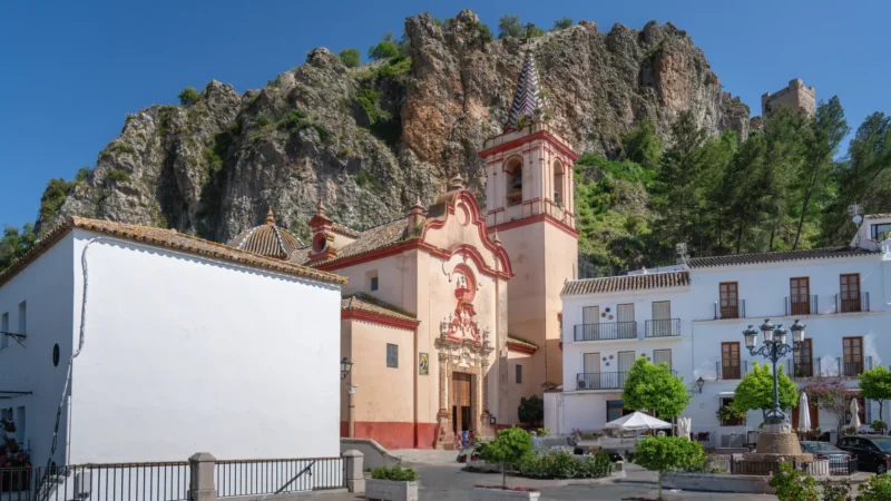The baroque façade and tiled bell tower of the Iglesia de Santa María de la Mesa below the castle, Zahara de la Sierra, Cádiz, Andalucía, Spain