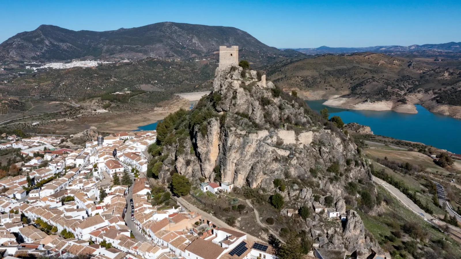 The castle keep of Zahara de la Sierra on its crag above the reservoir, Cádiz, Andalucía, Spain